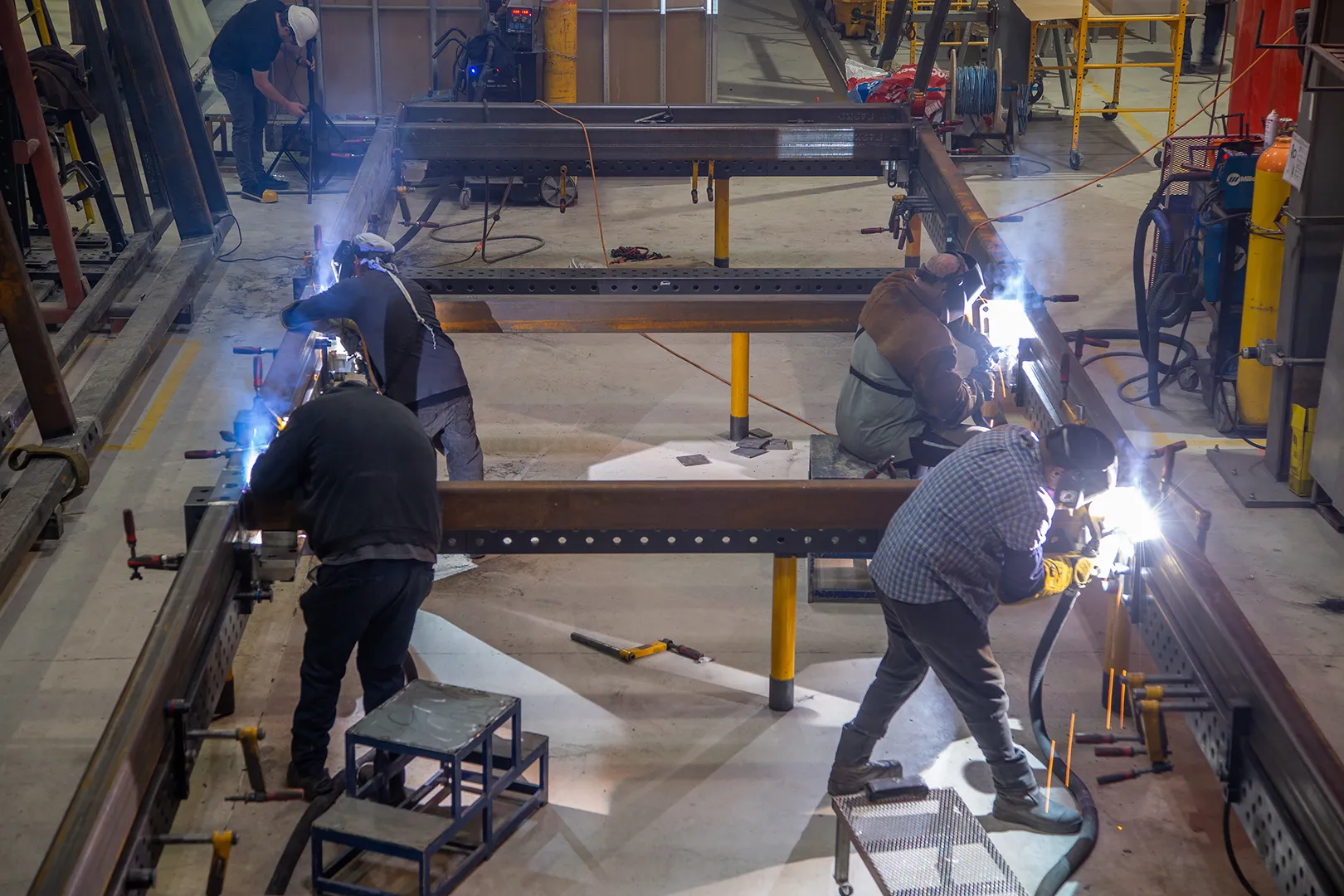 Welders fabricating a steel volumetric module chassis at Domo Manufacturing in San Diego